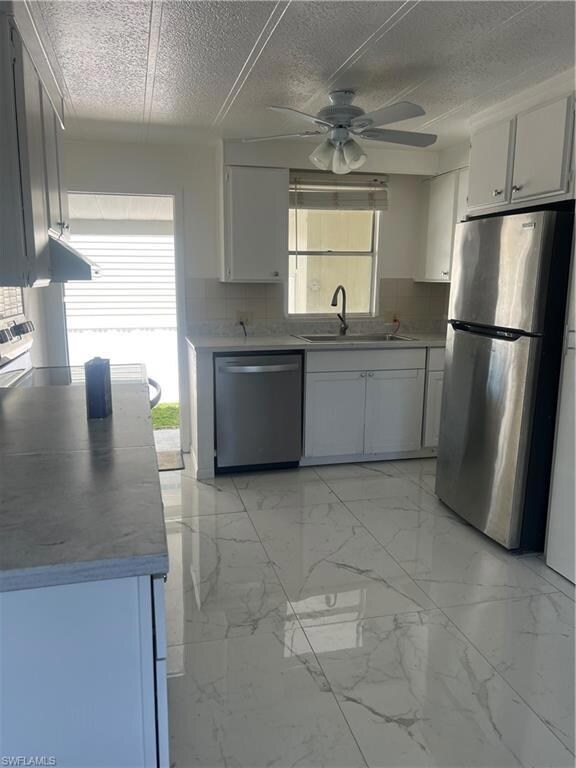 Kitchen with a ceiling fan, stainless steel dishwa