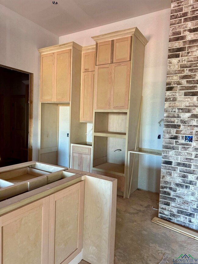 Kitchen featuring concrete flooring and light brown cabinetry