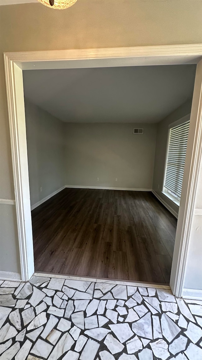 Unfurnished room with wood finished floors and baseboards
