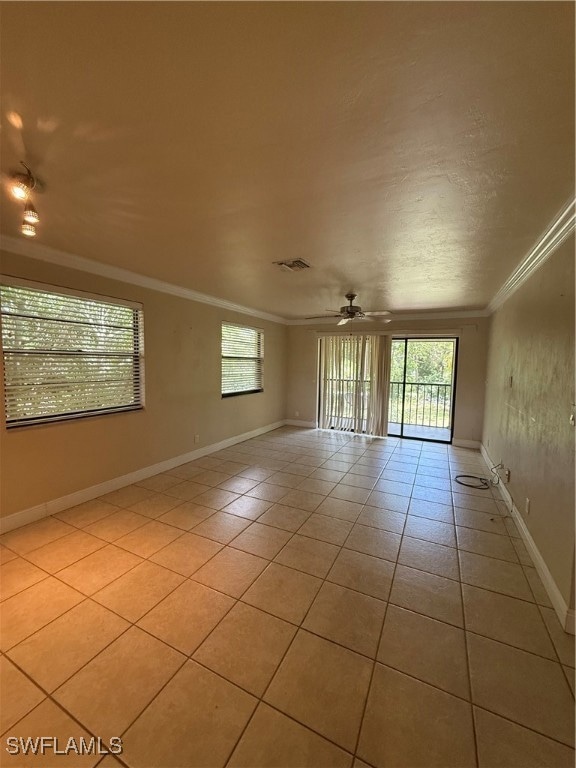 Empty room with plenty of natural light, crown molding, light tile patterned floors, and a ceiling fan