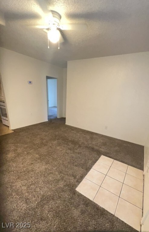 Carpeted spare room with a textured ceiling and ce