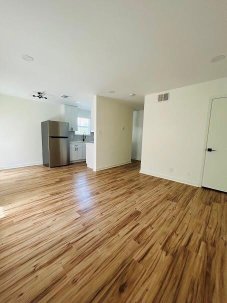 Unfurnished living room with light wood-type floo