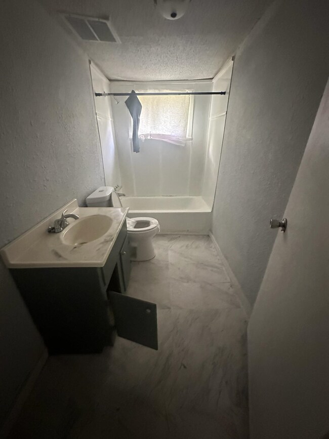 Full bathroom with vanity, a textured ceiling, sho