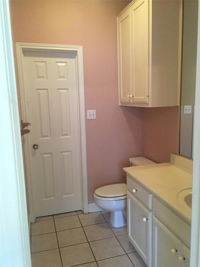 Half bath with vanity, toilet, tile patterned flo