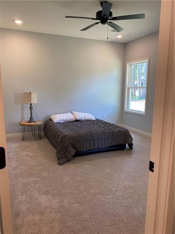 Carpeted bedroom with a ceiling fan and recessed lighting