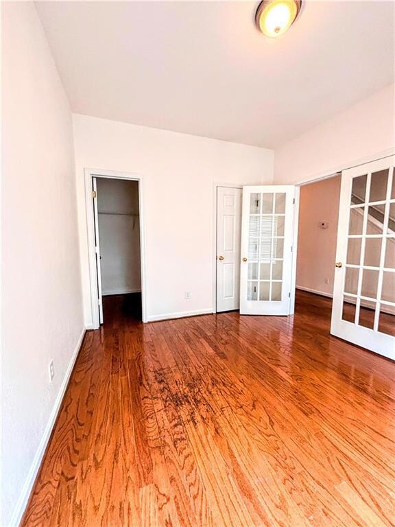 Unfurnished bedroom with baseboards, french doors,