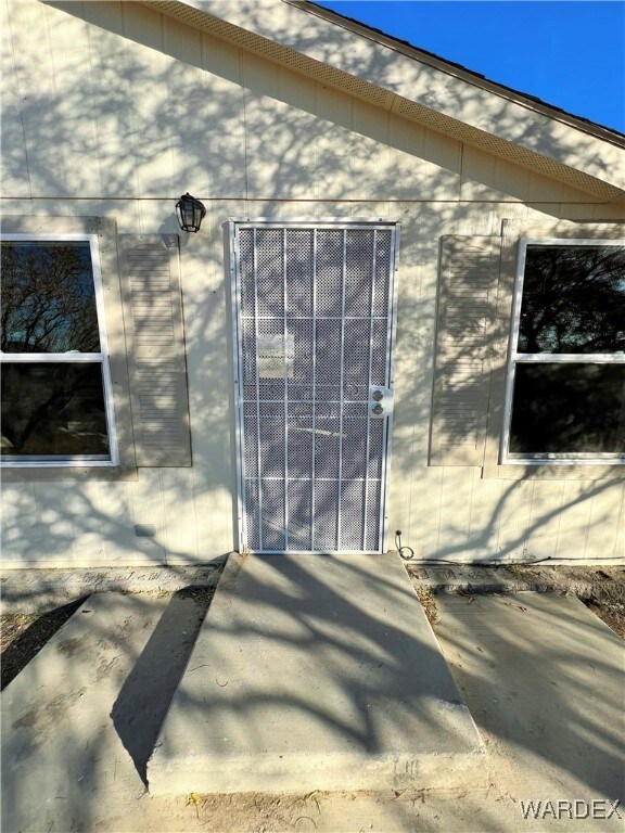 View of exterior entry with a patio