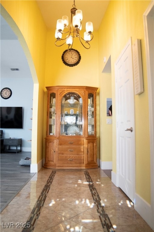 Foyer with arched walkways, a towering ceiling, a