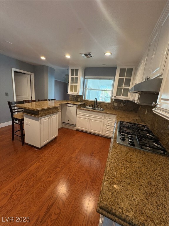 Kitchen with a sink, visible vents, white cabinetr