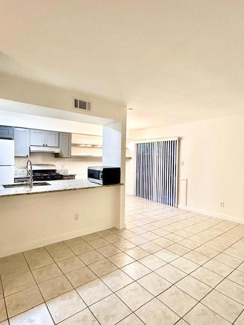 Kitchen featuring freestanding refrigerator, a si