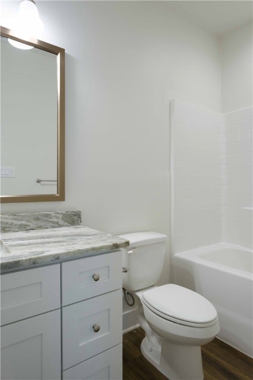 Full bath with vanity, dark wood-style flooring, and  shower combination