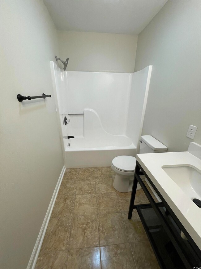 Bathroom with vanity, shower / bathtub combination, and light tile patterned flooring