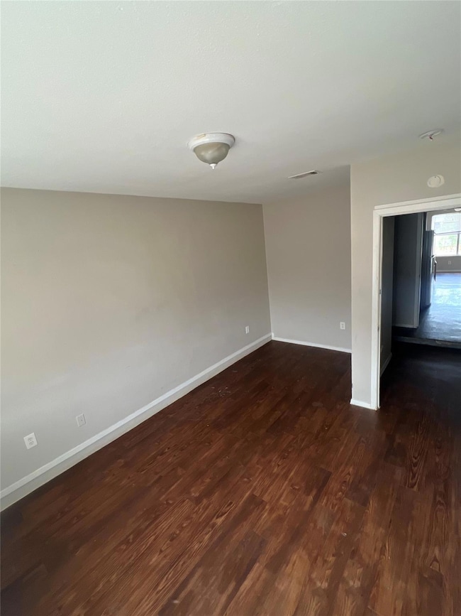 Empty room with dark wood finished floors