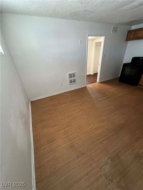 Empty room featuring a textured ceiling and basebo