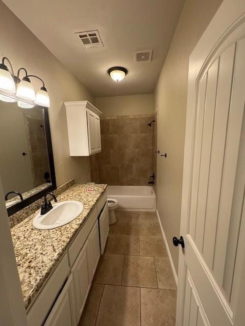 Full bathroom with tile patterned floors, vanity, toilet, and tiled shower / bath combo