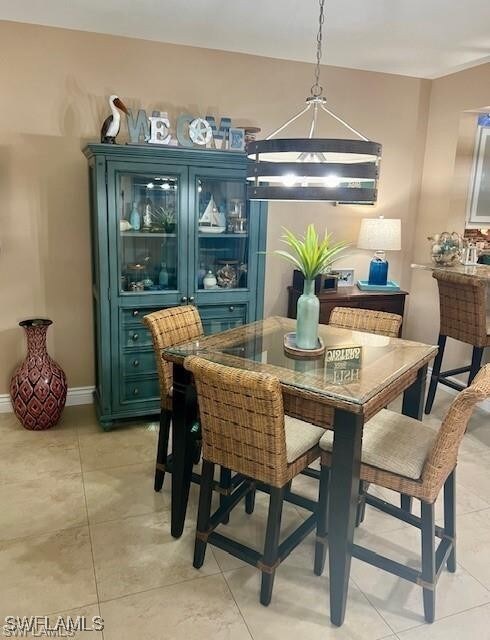 Dining space featuring light tile patterned floors and baseboards