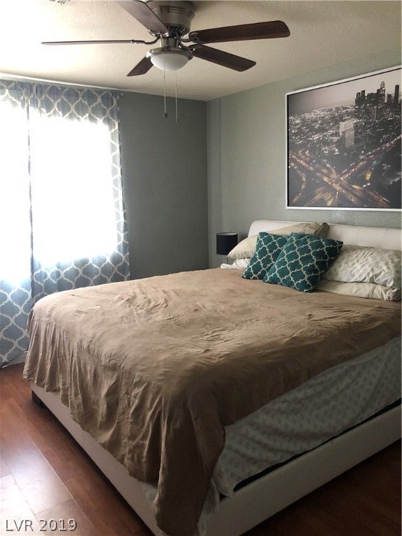 Large master with beautiful wood flooring, fans an
