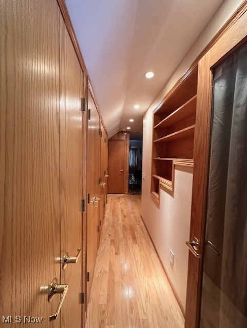 Hall with light wood-type flooring and recessed lighting