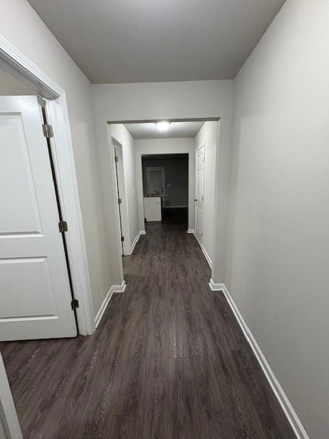 Hall featuring dark wood finished floors and baseboards