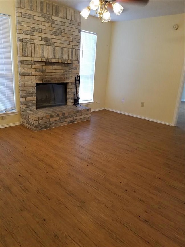 Unfurnished living room featuring a fireplace, ba