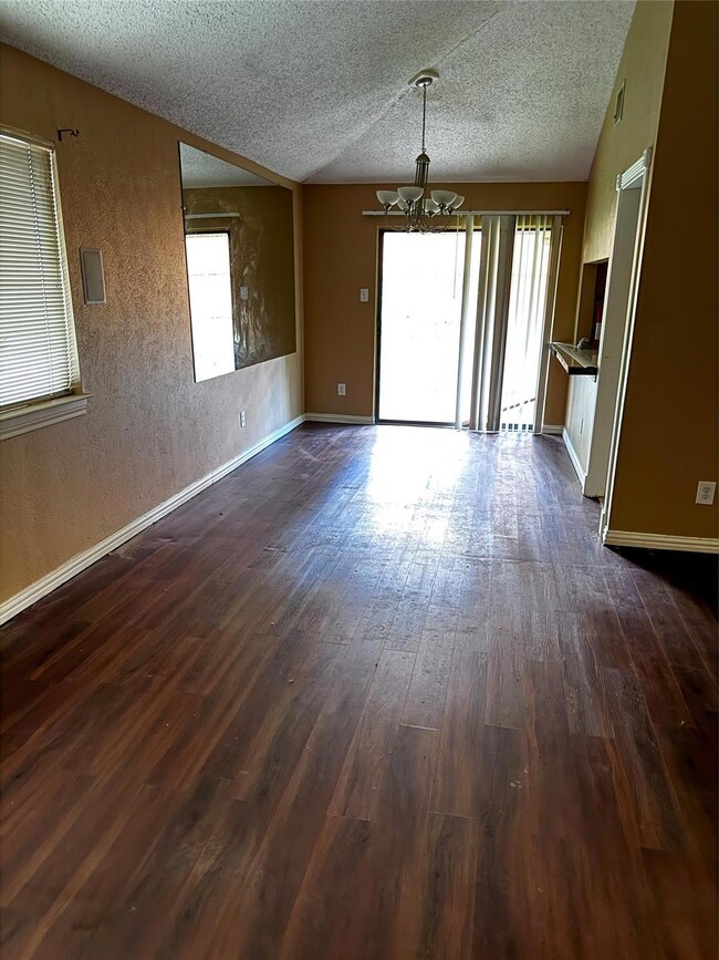 Empty room with dark wood-type flooring, an inviti