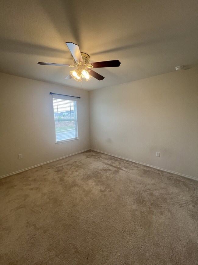 Empty room with carpet and ceiling fan