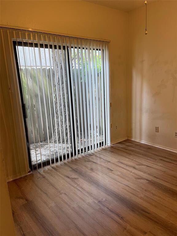 Empty room with baseboards and wood finished floo