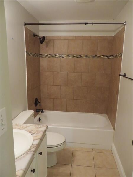 The Full Bath Features a Neutral Tile Surround & C