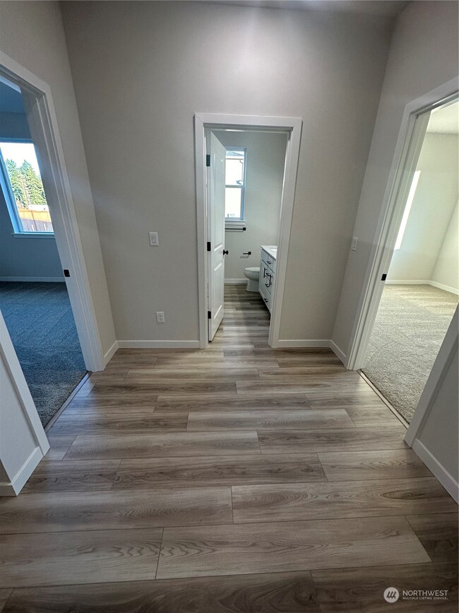 Hallway to bedrooms and secondary bath  Disclaimer: These photos are of another Aurora Home in community. Depictions of home, layout, location or other features, colors and color scheme, materials, fixtures, etc. are for showing purposes only and may not be included in the purchase price and availability may vary.