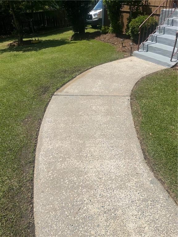 View of yard featuring fence and stairs