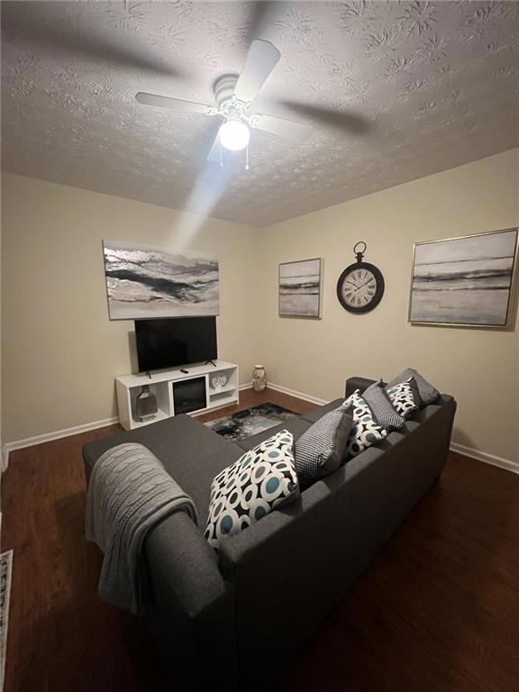 Living area featuring a textured ceiling, wood finished floors, and a ceiling fan
