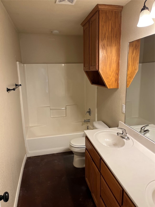 Full bath with double vanity, a textured wall, and shower / bathtub combination