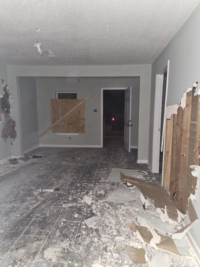 Empty room with baseboards and a textured ceiling