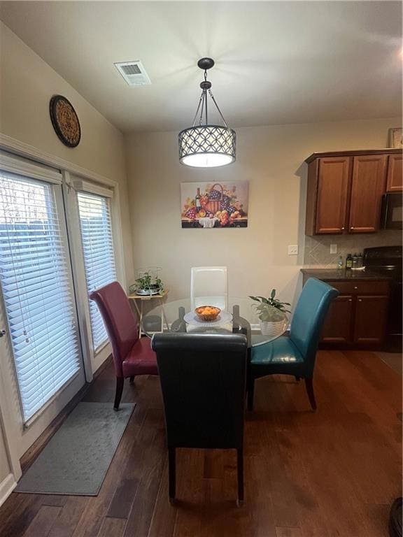 Dining room with dark wood-style floors and visibl