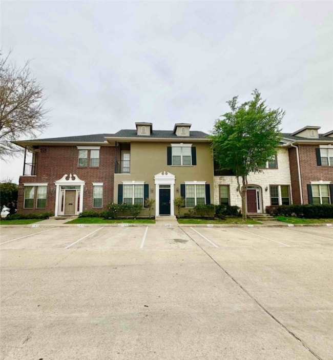 View of front of property featuring brick siding and uncovered parking