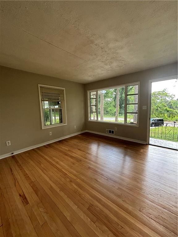 Spare room featuring baseboards, a textured ceilin