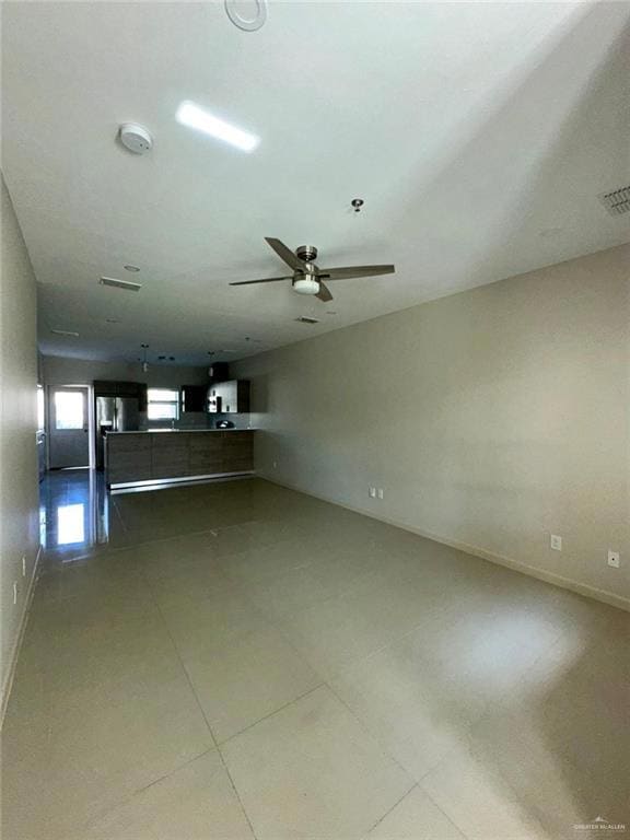 Unfurnished living room with baseboards and a ceiling fan