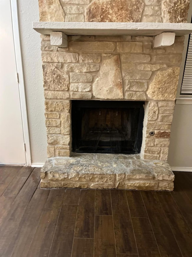 Detailed view of a stone fireplace and wood finished floors