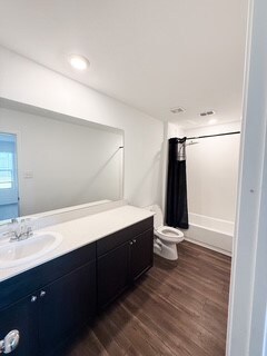 Full bathroom with vanity, dark wood finished floors, and recessed lighting