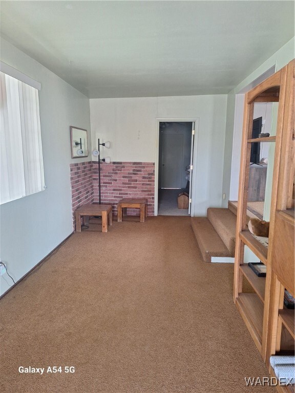 Living area with stairway and carpet flooring