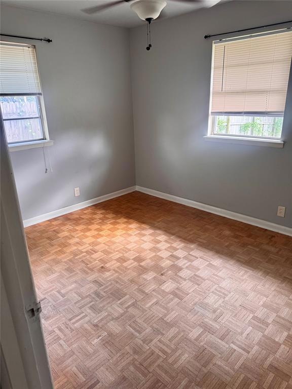 Empty room with ceiling fan and baseboards
