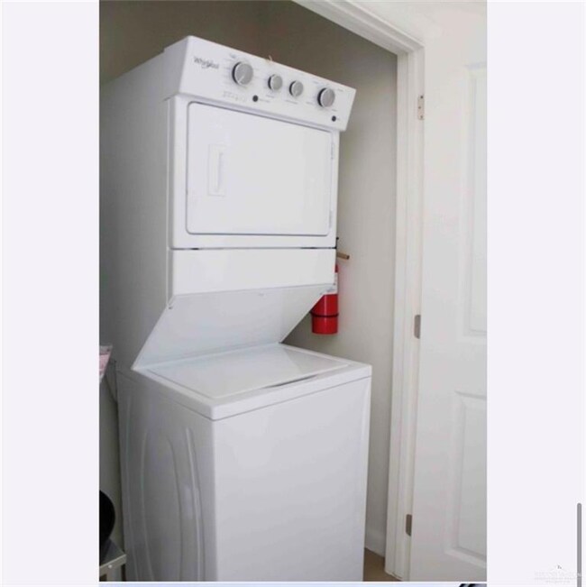 Washroom featuring stacked washer / dryer