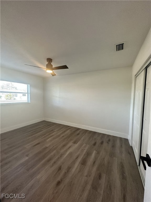 Spare room with dark wood finished floors and baseboards
