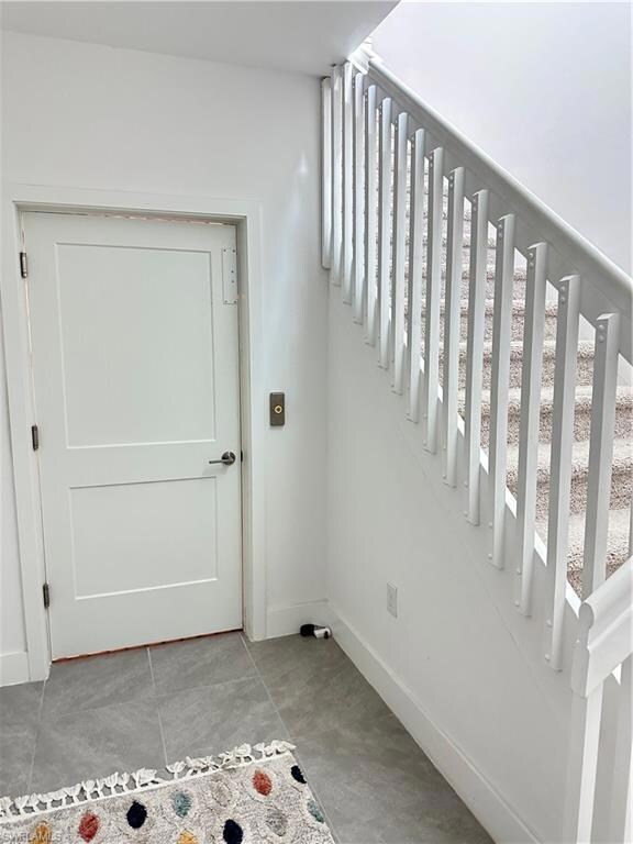 Staircase with baseboards and plenty of natural light