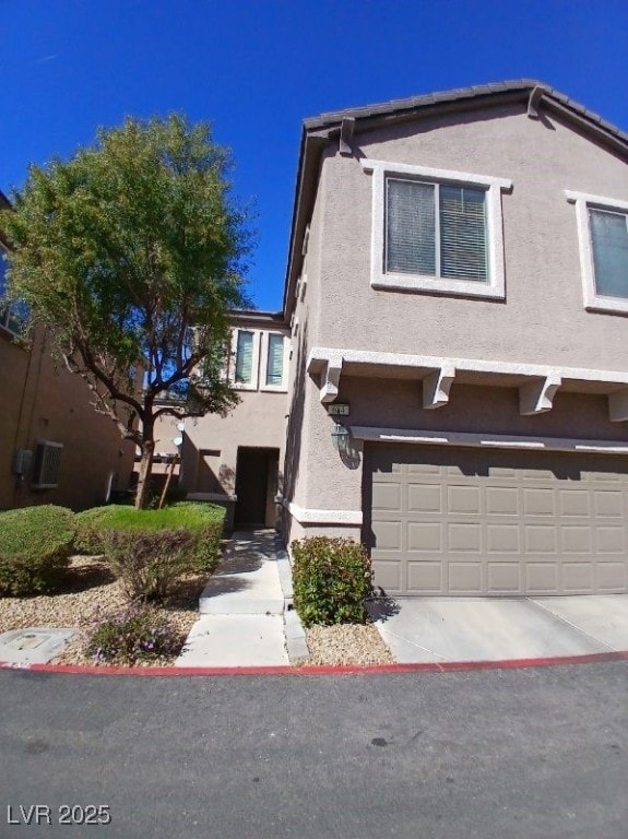 View of front of property featuring a garage, driv