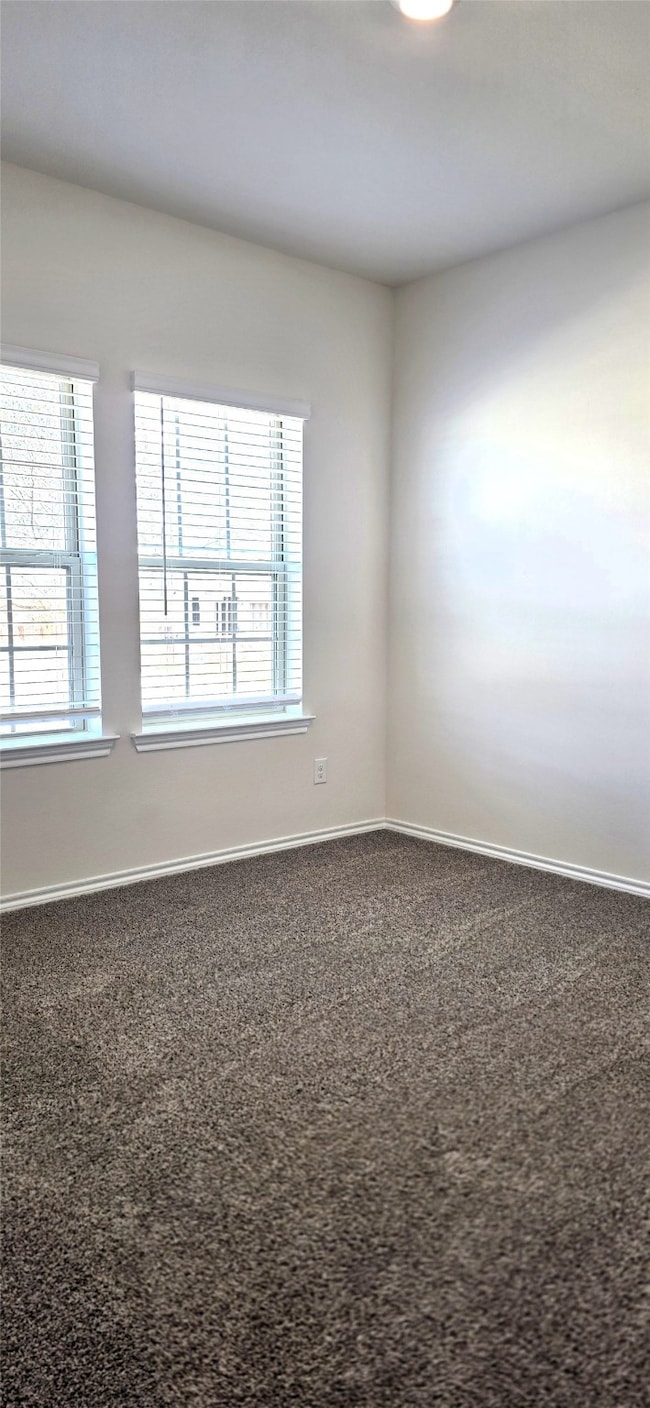 Carpeted spare room with baseboards