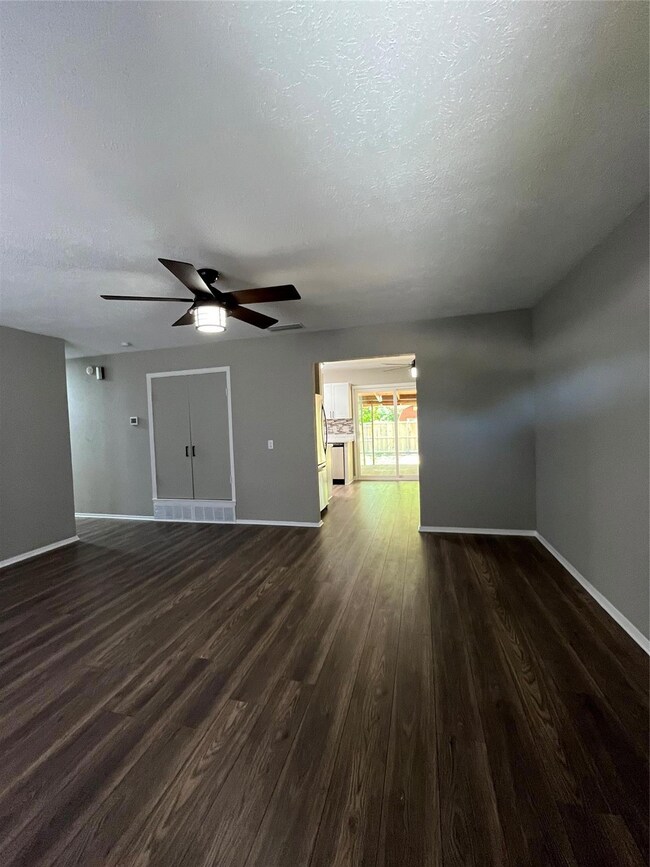 Spare room featuring wood-type flooring, a textured ceiling, and ceiling fan