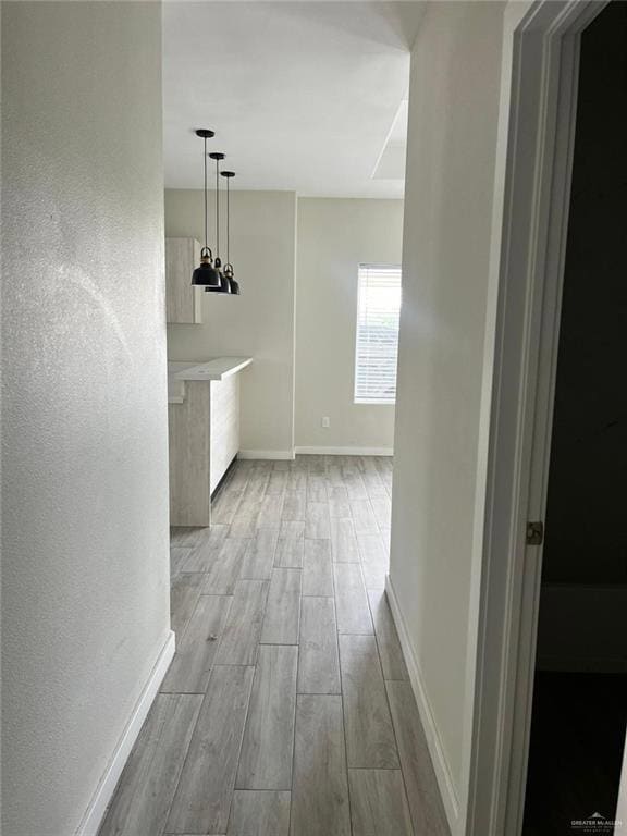 Hallway with wood tiled floors and baseboards