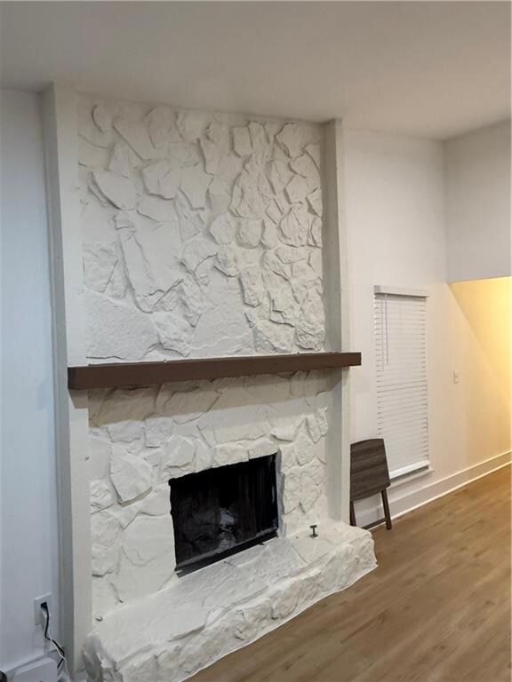 Detailed view of wood finished floors and a stone fireplace