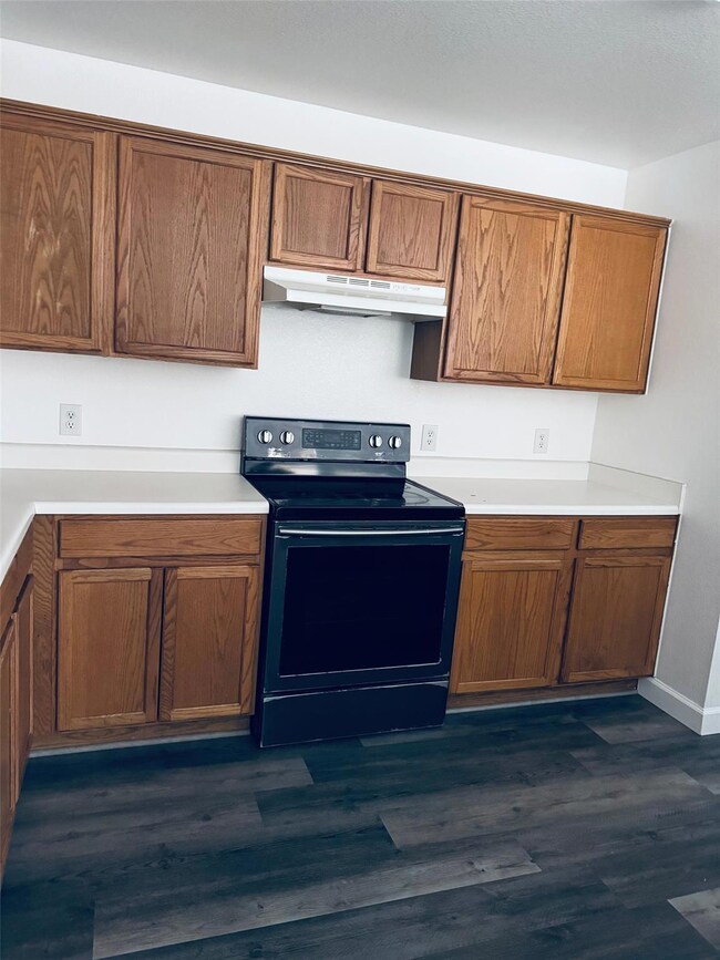 Kitchen with brown cabinets, light countertops, d